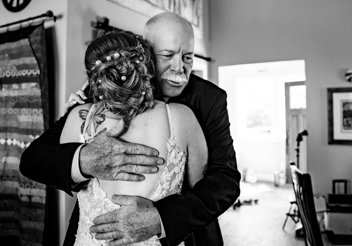 Bride's father hugs the bride before the wedding ceremony in Calgary.