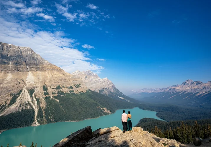 Couple in love adore stunning view if blue Peyto Lake and the Canadian Rockies.