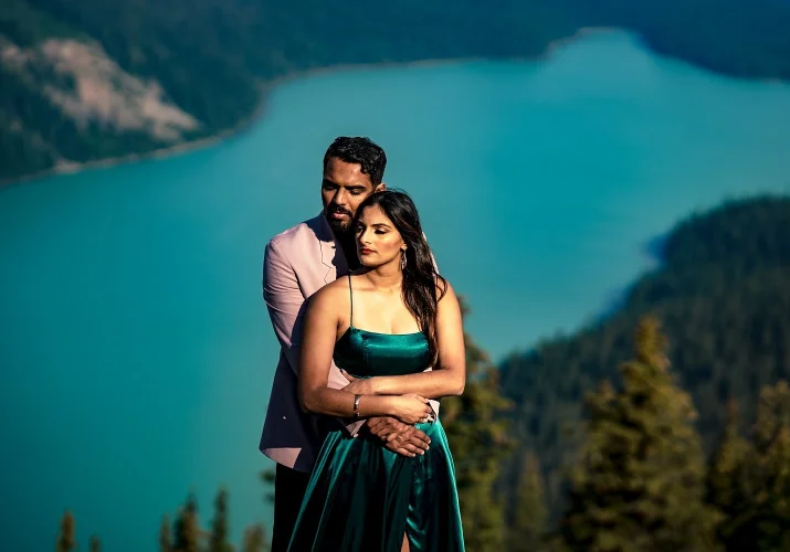 Man holds his fiancee from behind. Their eyes are closed.