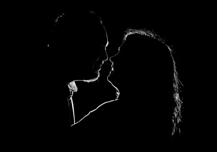 Back-lighted engaged couple in black and white