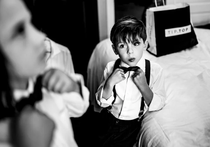 Black and white photograph of boys fixing their ties before Wedding Ceremony in the Canadian Rockies.