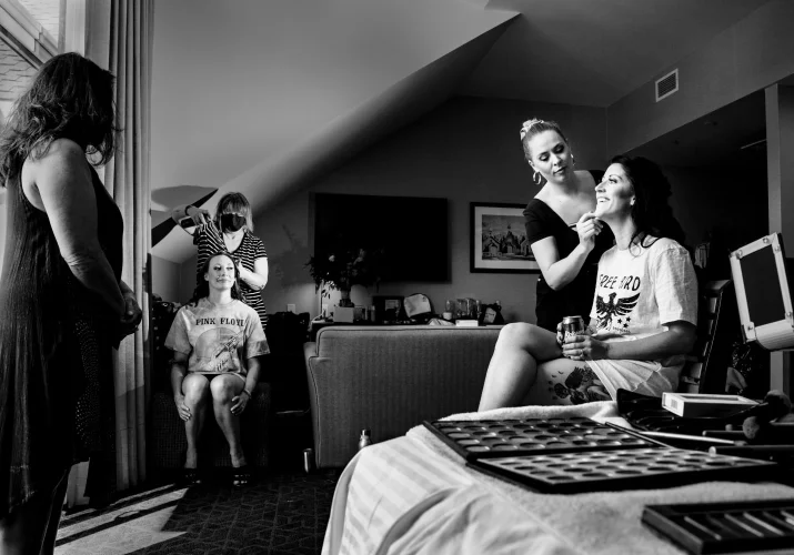 Bride and bridesmaid get their make up done in the hotel room. in Banff.