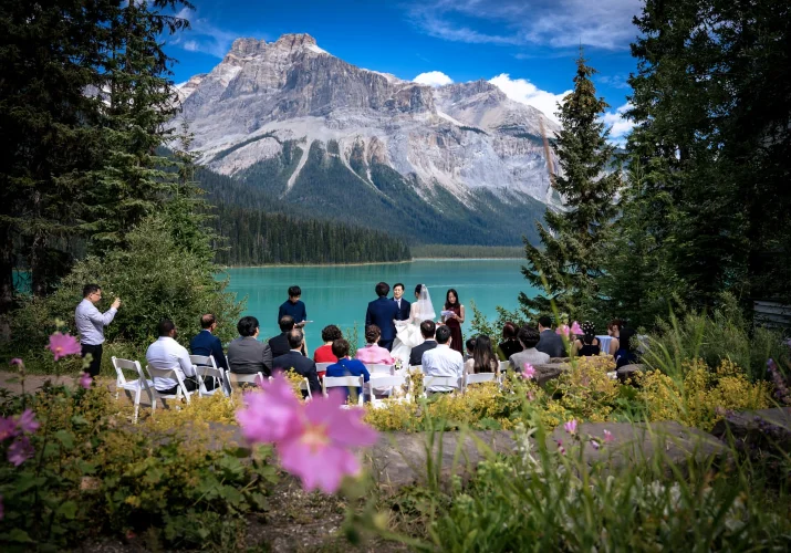 Unique wedding ceremony at Emerald Lake. Guests and newlyweds surrounds by Canadian Rocky Mountains,