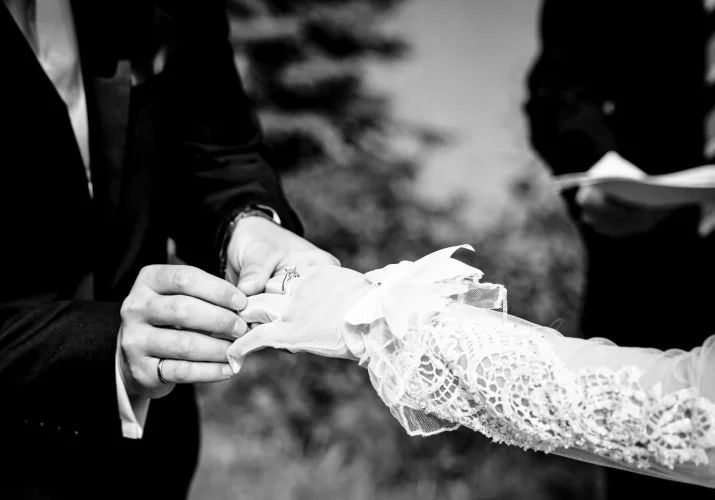 Groom puts a wedding ring on the bride;s finger