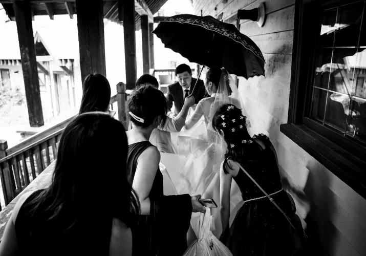Asian family rushing for a wedding ceremony. Photograph in black and white.