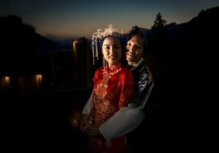 Bride and groom by the window in a hug in Banff hotel.