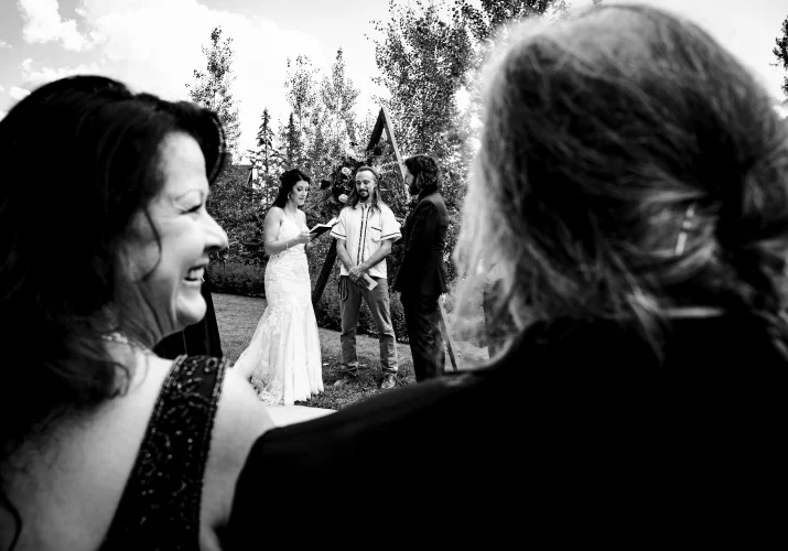 Amazing Candid Photograph in black and white. Shoot through the parents backs while their daughter is getting married in Banff.