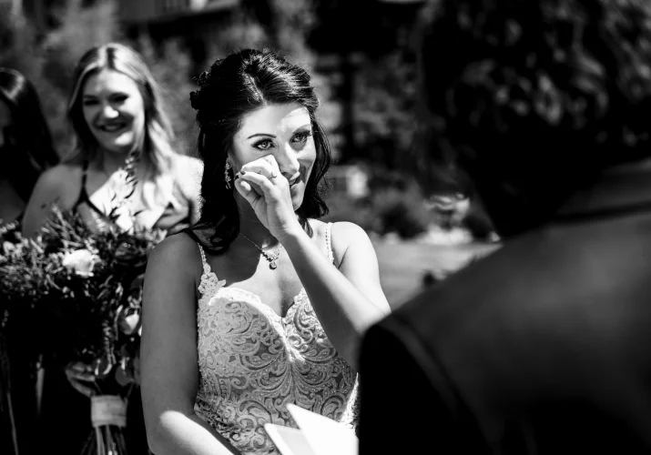 Bride wipes the treats from her cheek . Touching moment captured by best Calgary Wedding Photographer Lukas Slobodzian.