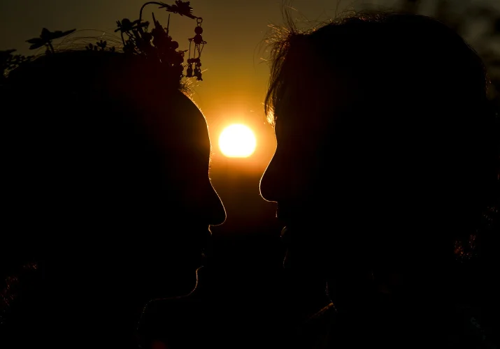 Romantic Photograph of newlyweds heads with sun in between them.