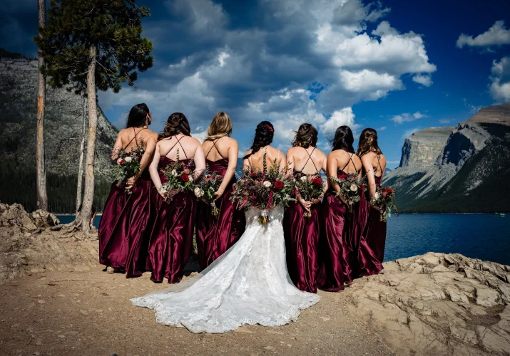 bride and bridesmaids turned back to camera and show their flowers.