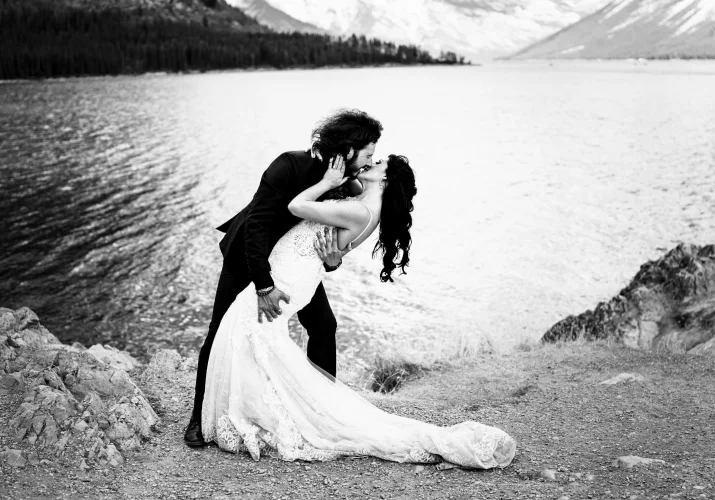 Broom dips his wife an kiss her at Minnewanka Lake.