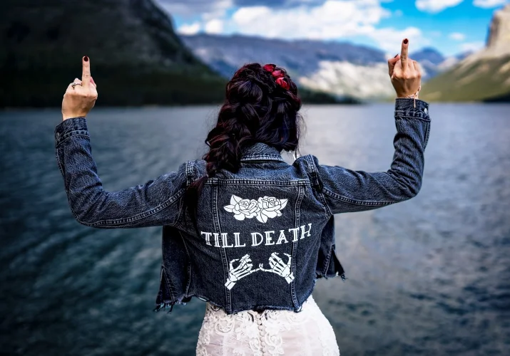 Bride facing the lake and showing her middle finger.