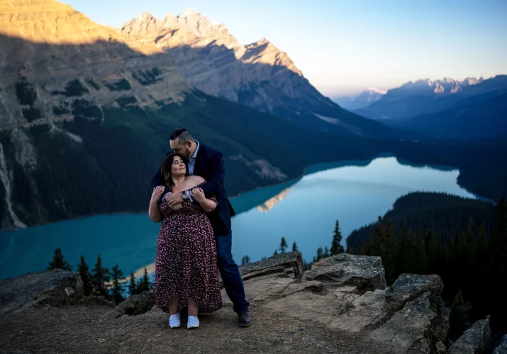 Engaged couple in love standing in a hug at amazing Peyto Lake in the Canadian Rockies.