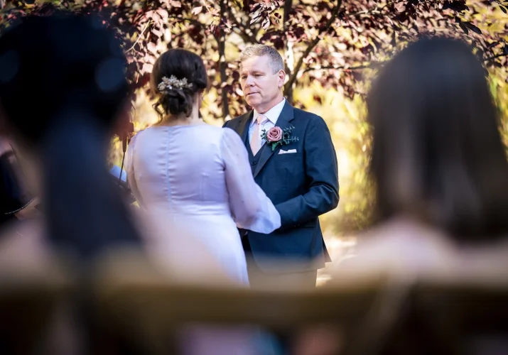 Bride and groom holds hands.