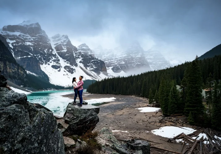 Couple in love announced their engagement by posing at glacially fed lake in Banff - Moraine Lake.. Moment captured by talented Banff Wedding Photographers.