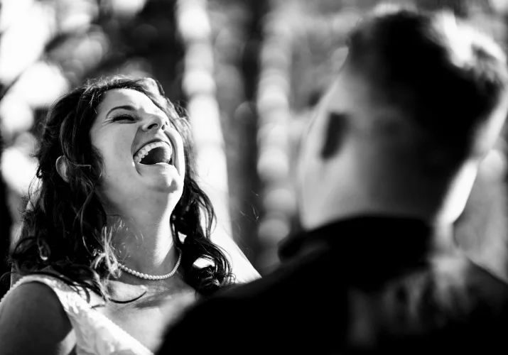 Funny moment captured by Banff Wedding Photographer of the bride laughing loud at the groom standing in front of her.