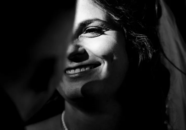 Calgary Wedding Photography in black and white. Bride look at the groom and her eye is lighted by sun.