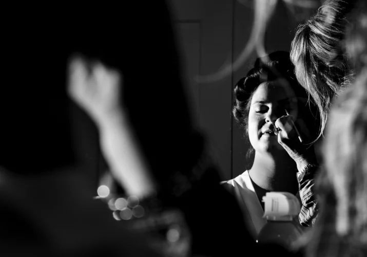 Creative photo in black and white of the bride having her make up done .