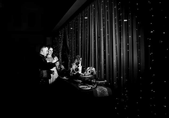 Calgary Wedding Photography in black and white. Bride and groom cutting a wedding cake.