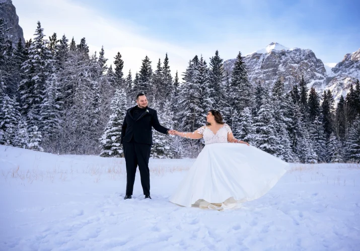 Bride and groom dance in the winter scenery in Banff. Photograph taken by Banff Wedding Photographers.