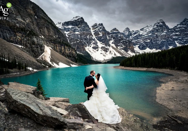 At Moraine Lake Bride and Groom Celebrate Their love and admire the beauty of the turquoise lake in the Canadian Mountains