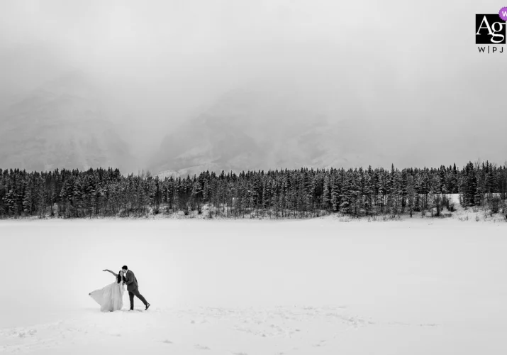 Bride and Groom celebrating their love at the frozen lake in Kananaskis Country. Moment captured by Banff Wedding Photographer.
