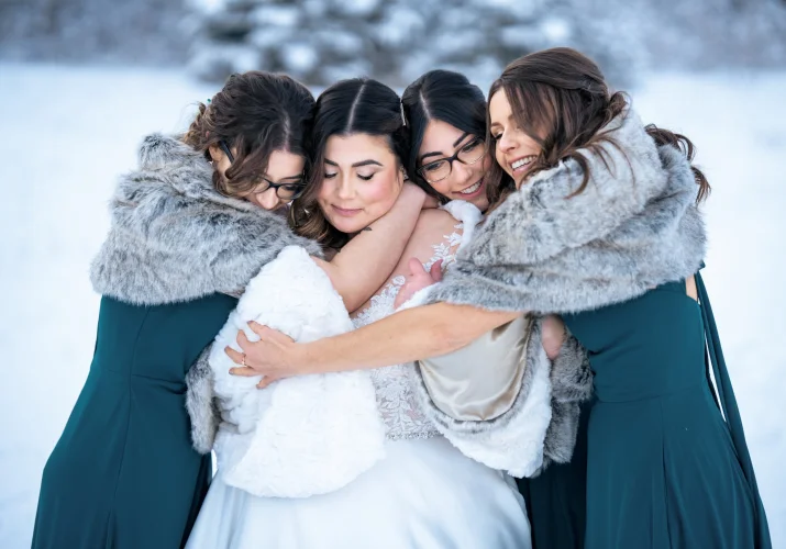 Bridesmaids give a hug to the bride.