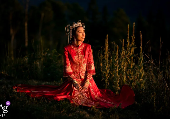 Bride wearing traditional Chinese wedding dress sitting on the ground