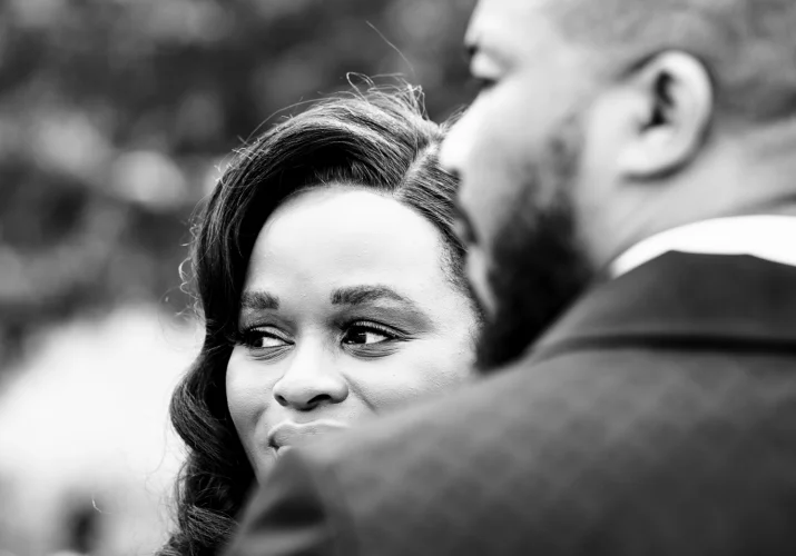 Bride and groom faces looking away in black and white.
