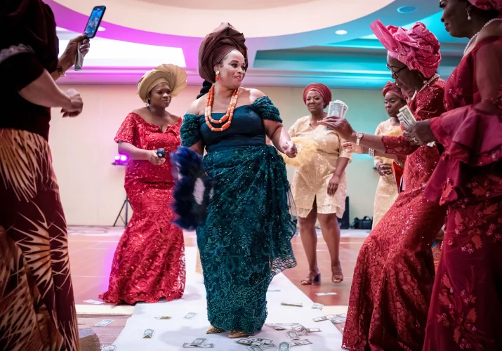 Entrance of the bride at the Nigerian Wedding in Calgary. She wears a green traditional attire. Her Familly around her dancing with her.